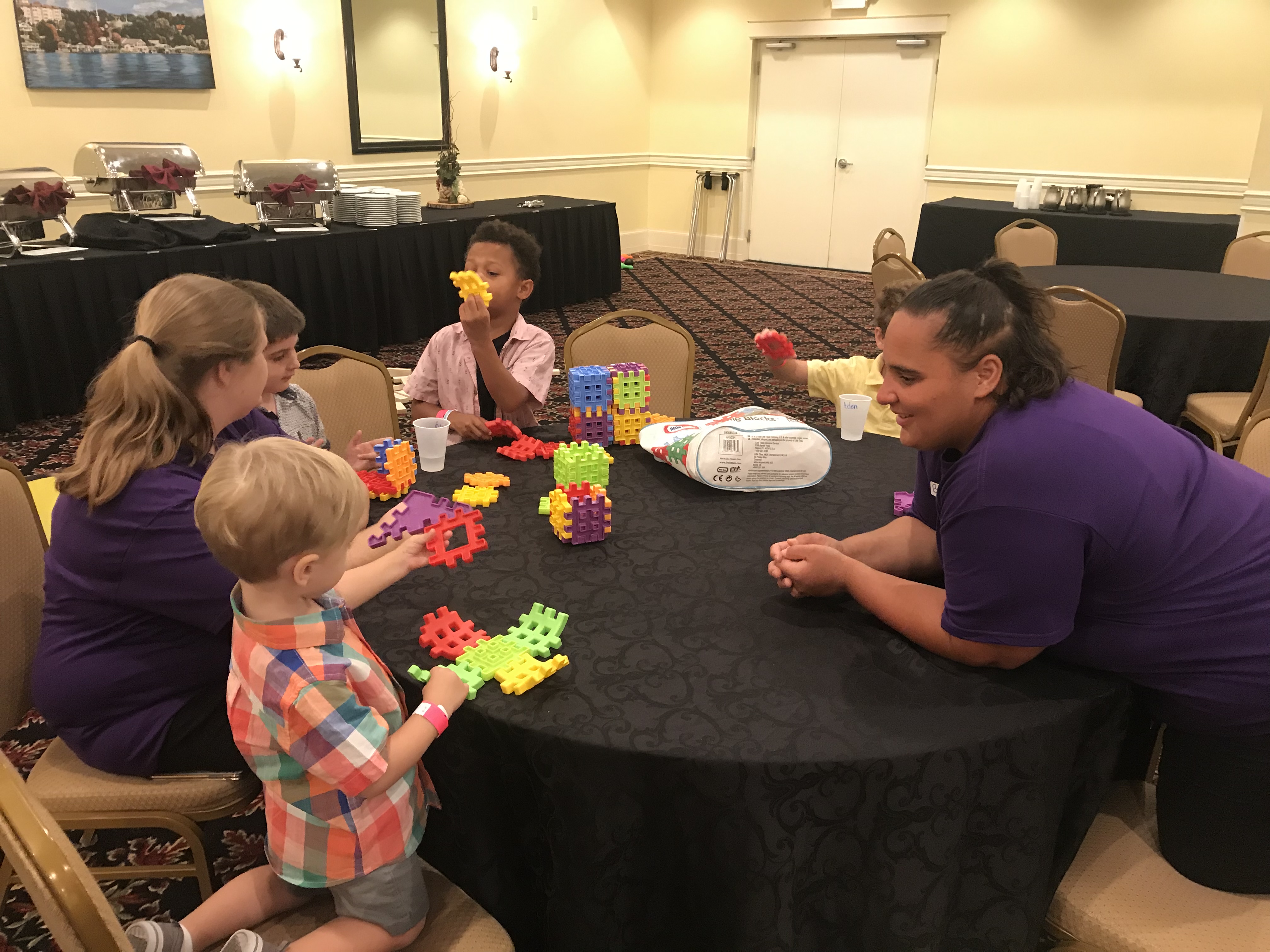 Sitters (Janice & Brittani) playing at the table with kiddos at Lake Receptions in Mt Dora.